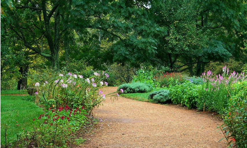 Ein pflegeleichter Garten mit einem Kiespfad und Blumenbeeten.